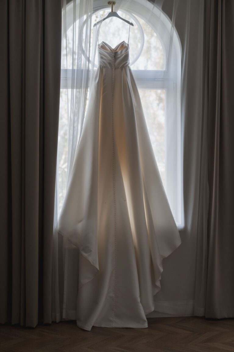 suknia panny młodej wisząca na oknie