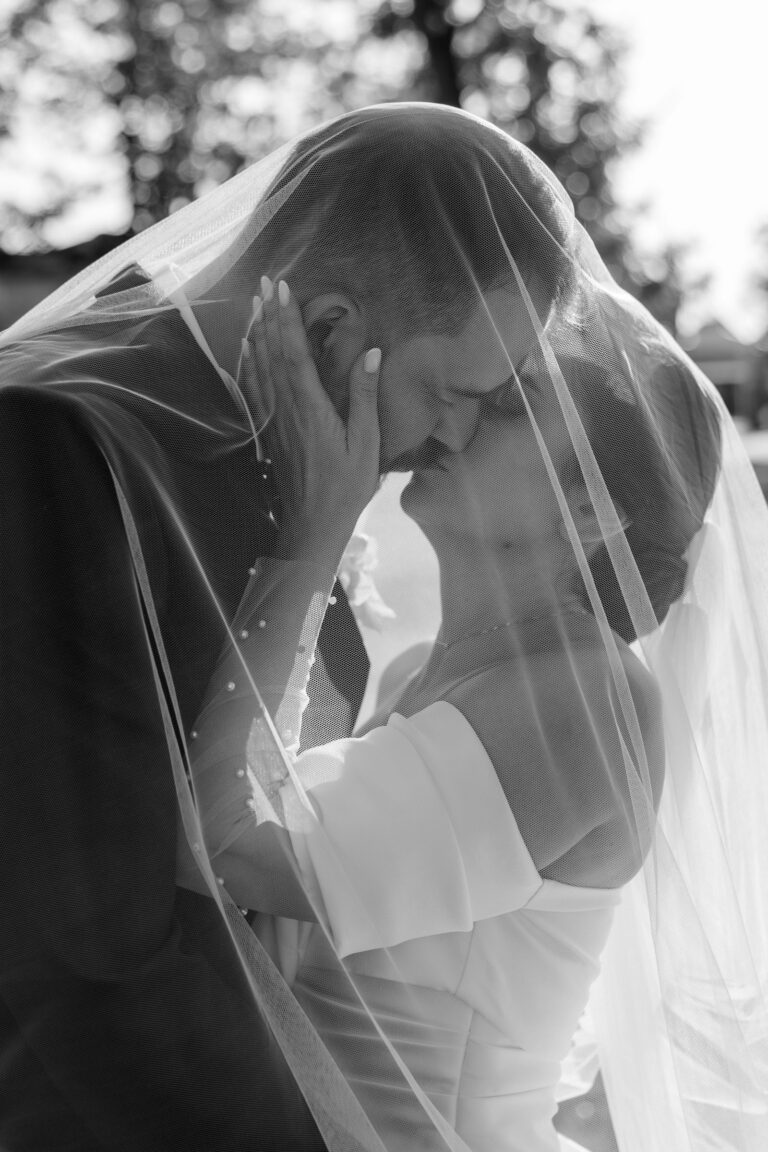 pocałunek pod welonem młodej pary