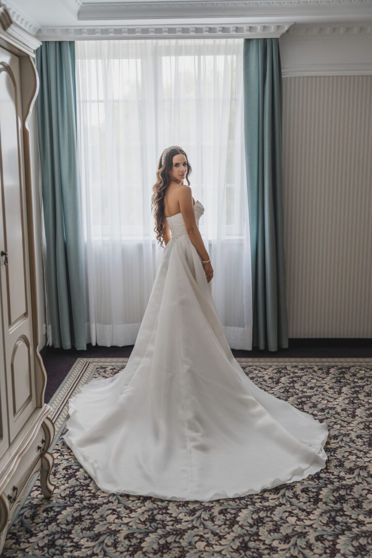 panna młoda w sukni przed ślubem z długim trenem